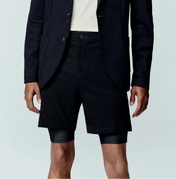 Homem vestindo bermuda preta de alfaiataria com blazer